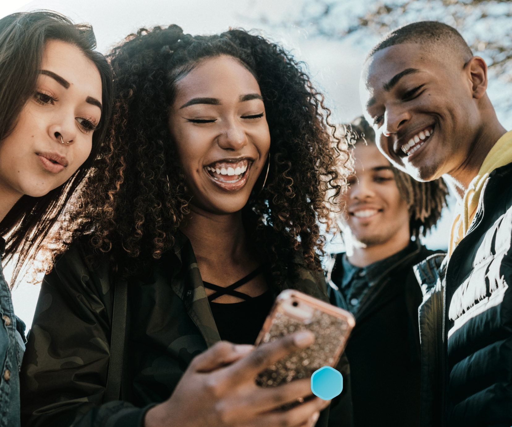 Group of friends laughing together while looking at a phone